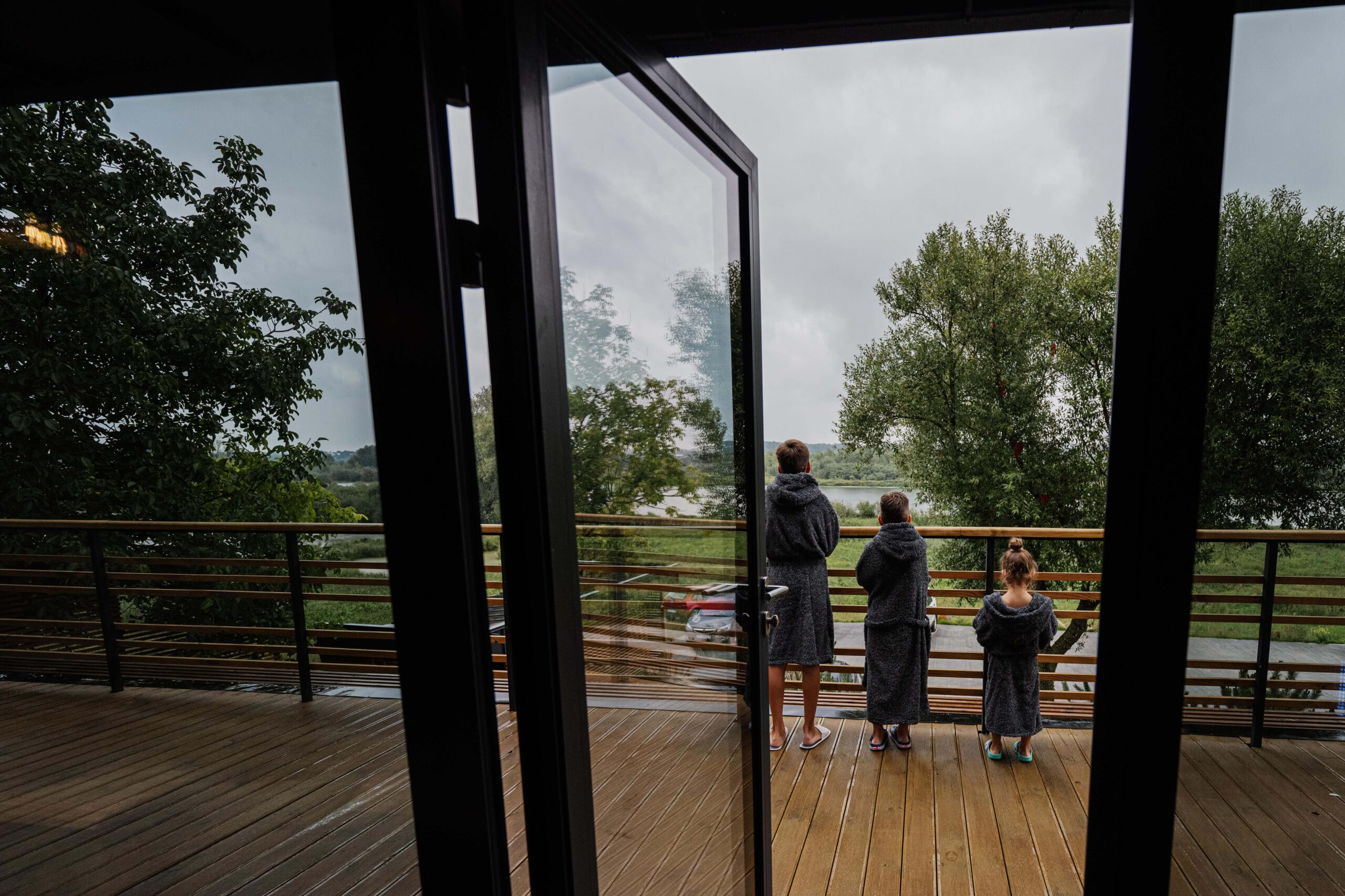 widok na taras przez duże przeszklenia w nowoczesnym domu